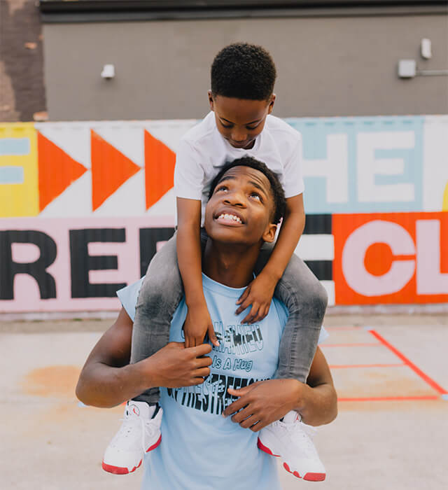boy sitting on his friend's shoulders