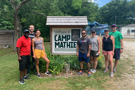 group of volunteers standing in front of the Camp Mathieu sign