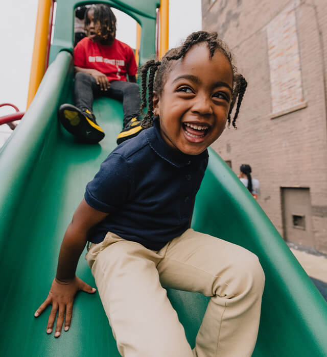 A boy and a girl laughing on a slide