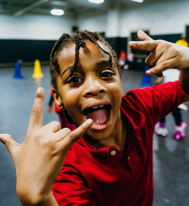happy kid throwing up rocker fingers